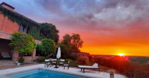 a swimming pool with a sunset in the background at LA USINA VIEJA in Esquina