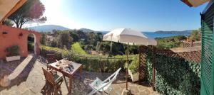 patio con tavolo e ombrellone di Ca' La Stella Sea-view Apartments a Porto Azzurro