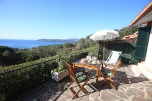 - une table et des chaises sur une terrasse avec vue sur l'océan dans l'établissement Ca' La Stella Sea-view Apartments, à Porto Azzurro