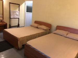 1 dormitorio con 2 camas y espejo en Wilpattu Wildhideaway, en Galkadawala