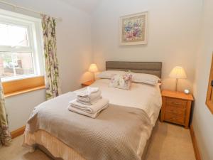 ein Schlafzimmer mit einem Bett mit Handtüchern darauf in der Unterkunft Rose Cottage in Penrith