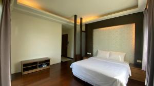 - une chambre avec un lit blanc et une fenêtre dans l'établissement Kenting Jinjin Music Inn, à Kenting