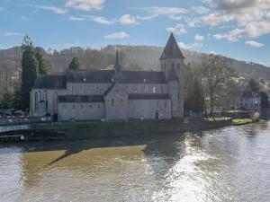 een groot kasteel aan de kant van een rivier bij Cosy holiday home in Hasti re with a terrace in Hastière-par-delà