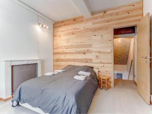 een slaapkamer met een bed en een houten muur bij Cosy holiday home in Hasti re with a terrace in Hastière-par-delà