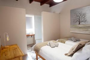 1 dormitorio con 2 camas y una pintura de árbol en la pared en Amande Guesthouse en Moorreesburg
