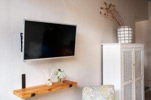 TV de pantalla plana colgada en la pared en Amande Guesthouse en Moorreesburg