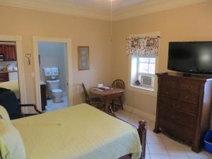 a room with a bedroom with a bed and a television at Chipman Hill Suites - Union Street in Saint John