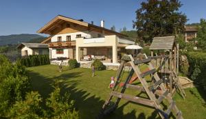 a house with a playground in the yard at Alpine Active Weitgasser in Flachau