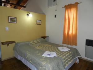 1 dormitorio con 1 cama con toallas en Complejo Los Molles en Potrero de los Funes