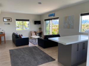 a kitchen and living room with couches and a table at Mahina Cottage in Twizel