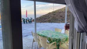 a table and chairs in a room with a window at Casa al sol in Adra