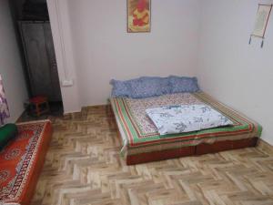 um quarto com uma cama e piso em madeira em BOJO House em Gangtok