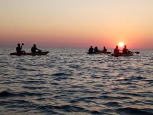 a group of people in kayaks on the water at sunset at Casa Berardi Residenza Storica in Ortona