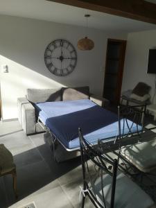 een slaapkamer met een bed en een klok aan de muur bij Appartement au calme à Pernes 1 chambre in Pernes