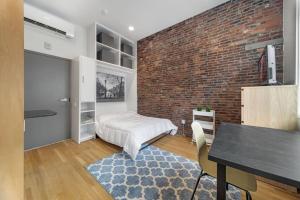 a bedroom with a bed and a brick wall at Simple Furnished Studio in The Heart of Boston in Boston