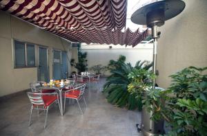 eine Terrasse mit Tischen, Stühlen und Pflanzen in der Unterkunft Hotel Ciutat De Sant Adria in Sant Adria de Besos