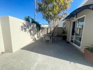 a patio with chairs and a tree next to a house at 10 on Aquavista Addo River Apartment in Colchester