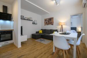 - un salon avec une table blanche et un canapé dans l'établissement Apartment EMARO, à Dubrovnik
