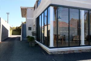 a building with glass windows on the side of it at THE PLACE Muizenberg in Muizenberg
