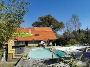 a swimming pool in front of a house at Les Hôtes Landes in Saint-Gor