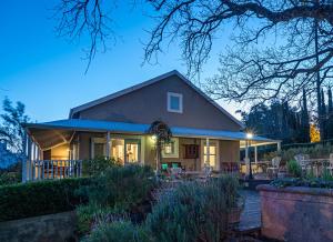 ein Haus mit einer Terrasse und Stühlen davor in der Unterkunft De Oude Pastorie in Swellendam