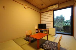 Habitación con mesa, sillas y ventana en リバティーリゾート久能山 