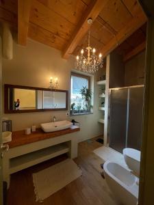 弗拉塔溫泉的住宿－BeB montefratta，带浴缸、水槽和吊灯的浴室