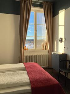 a bedroom with a bed and a large window at Stilleben Hotell in Åmot