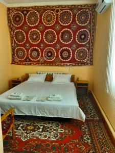 ヒヴァにあるRoyal Khiva Hotelのベッドルーム1室(大きな赤い壁のベッド1台付)