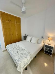 ein Schlafzimmer mit einem großen weißen Bett und einem Nachttisch in der Unterkunft TAÍNA Apartamento in La Envia