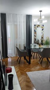 a dining room with a table and chairs and a mirror at Mariposa in Smederevo