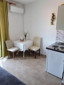 a kitchen with a table and two chairs and a stove at Villa Ilona in Primošten