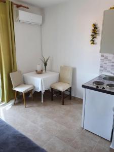 a kitchen with a table and two chairs and a stove at Villa Ilona in Primošten +17 photos