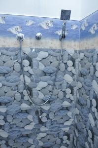 a shower with rocks and a shower head at Arusha Guest House in Negombo