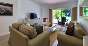 a living room with two couches and a tv at Victory Village 20B in Quinta do Lago
