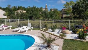 un patio trasero con piscina, sillas y una valla en Gite Pourquoi Pas, en Montégut-Lauragais