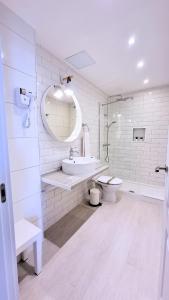 een witte badkamer met een wastafel en een toilet bij Caléndula Beach 1ºLinea mar in Caleta de Sebo