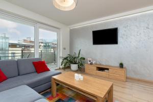 a living room with a couch and a tv at Apartament 14ka. Ustroń in Ustroń