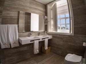 a bathroom with a sink and a mirror at Hotel Fonte Velha in Ponte da Barca