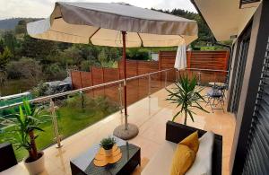uma varanda com um guarda-chuva e uma mesa em Nobless Apartments Holedná Brno em Brno