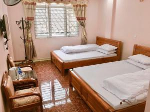 a bedroom with two beds and a window and a table at Ancient Town 29 Phố Cổ in Dồng Văn