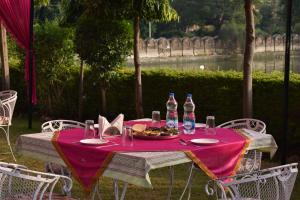una mesa con una bandeja de comida y botellas de agua en Hotel Nawal Sagar Palace - Bundi, en Bundi