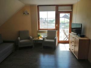 sala de estar con 2 sillas y TV en Two bedroom apartment with swimming pool en Gyenesdiás