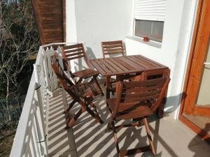 twee stoelen en een houten tafel op een veranda bij Two bedroom apartment with swimming pool in Gyenesdiás