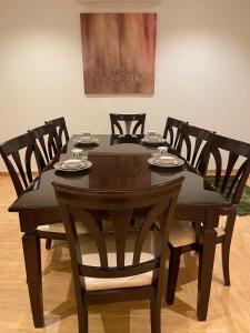 tavolo da pranzo con sedie, tavolo nero e chairsktop di Strings Chalet a Riyad