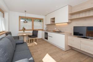 eine Küche und ein Wohnzimmer mit einem Sofa und einem TV in der Unterkunft Wiedmairhof in Uttenheim