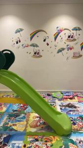 a green slide on the floor with umbrellas at Strings Chalet in Riyadh