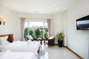 a hotel room with two beds and a television at Kanchanaburi City Hotel - SHA Extra Plus in Kanchanaburi