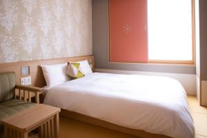 a bedroom with a bed and a chair and a window at Onyado Nono Kyoto Shichijo Natural Hot Spring in Kyoto +110 photos