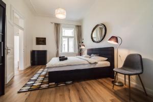 una camera con letto, sedia e specchio di Charles Bridge - 3 bedroom Apartment - Old Town a Praga